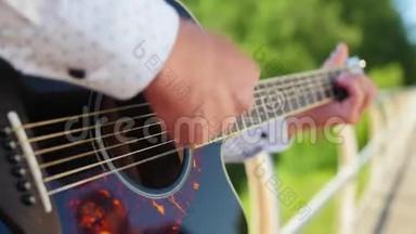 男人弹吉他。 吉他手在触摸吉他弦。 近距离射击。